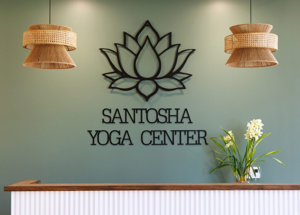 Santosha Yoga Center reception area featuring a decorative lotus design and plants, creating a calm and welcoming atmosphere for visitors.